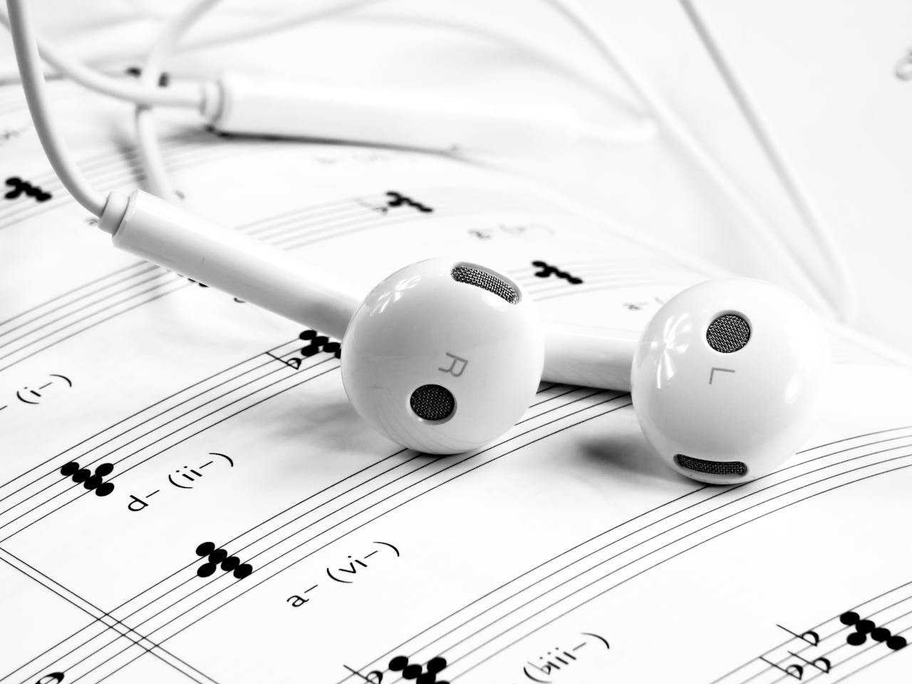services-img Close-up of white earphones resting on sheet music, emphasizing music and sound themes.