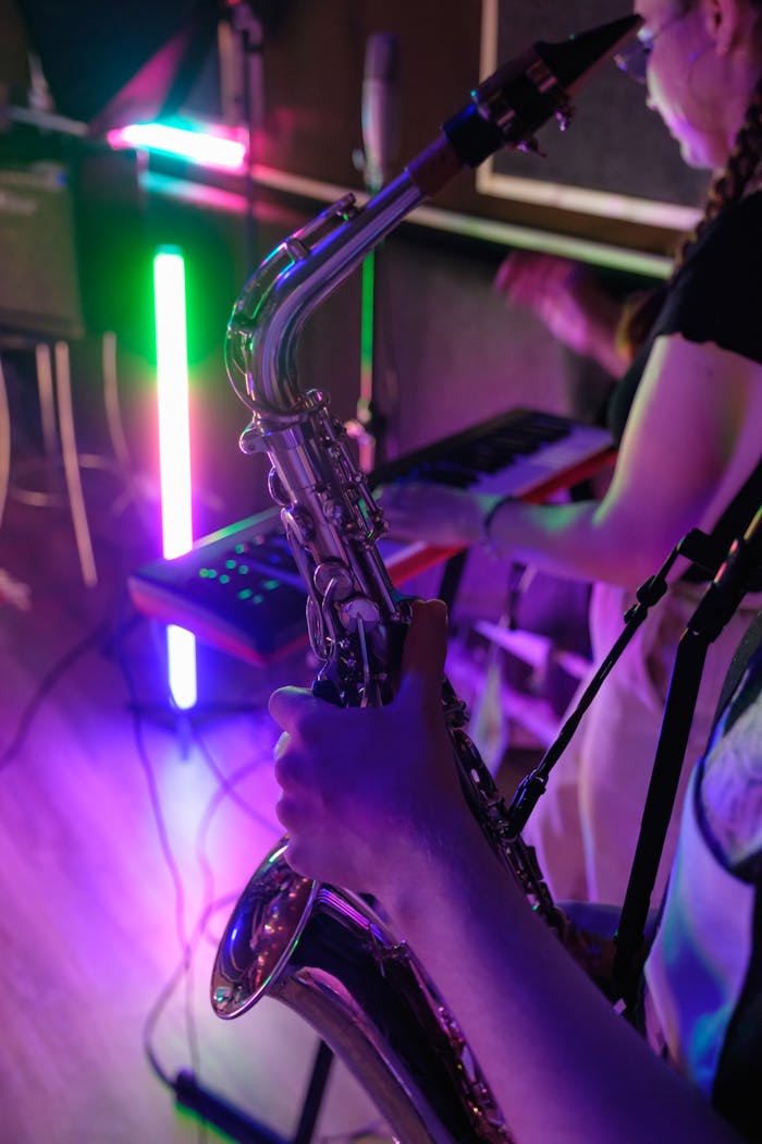 Musicians practicing with saxophone and keyboard in a colorful studio setting.